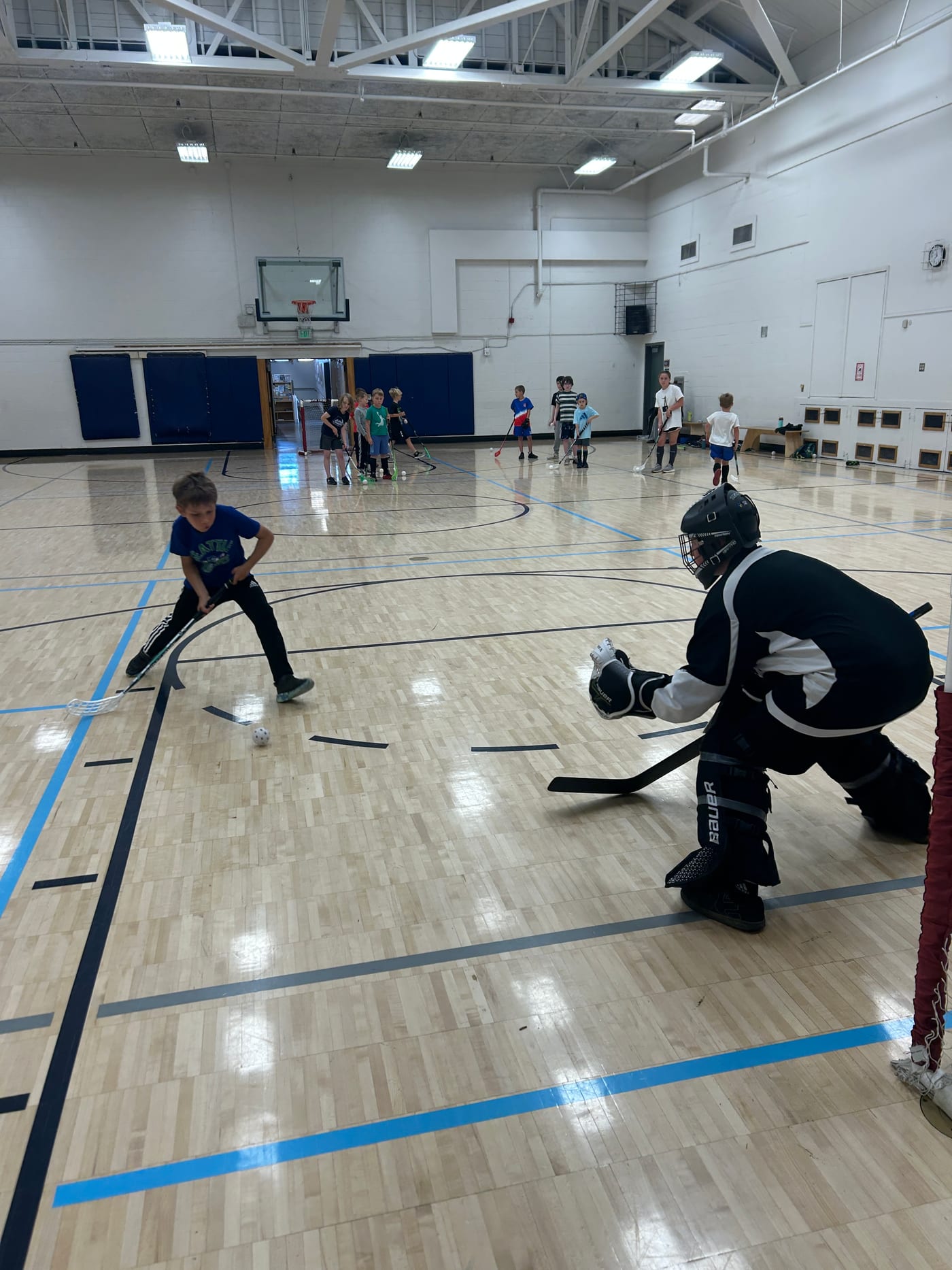 A young player taking a shot on the goalie