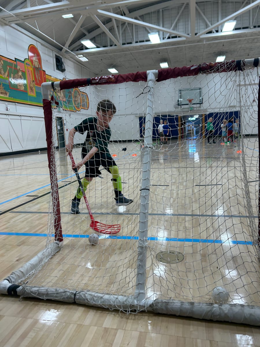A young player scoring into the net during Friday night ball hockey