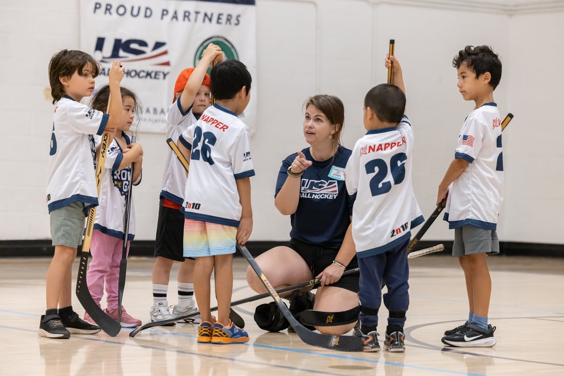 A coach leads a group of young players during instruction