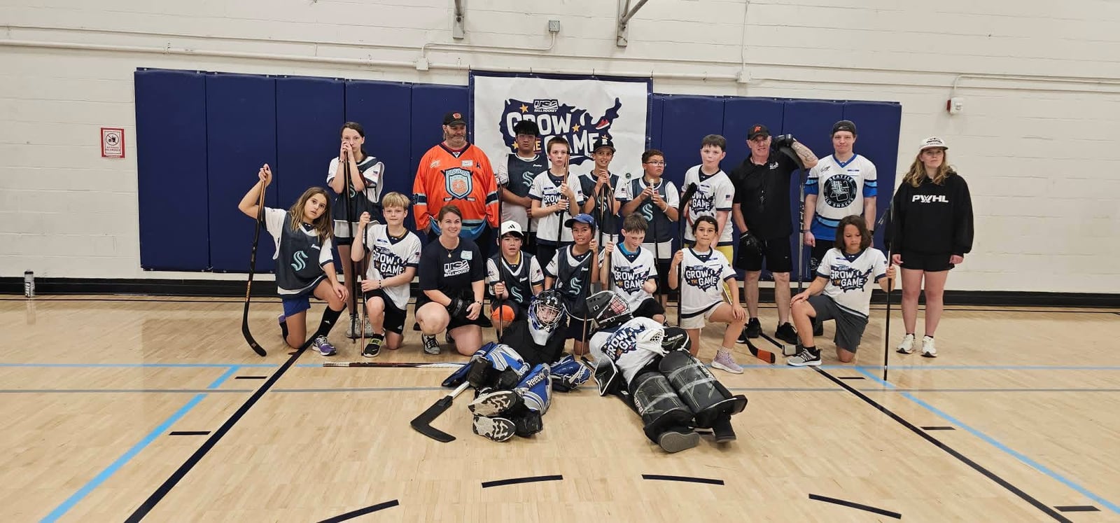 The full Grow the Game Day Seattle team gathered in front of the banner at the Frances Anderson Center