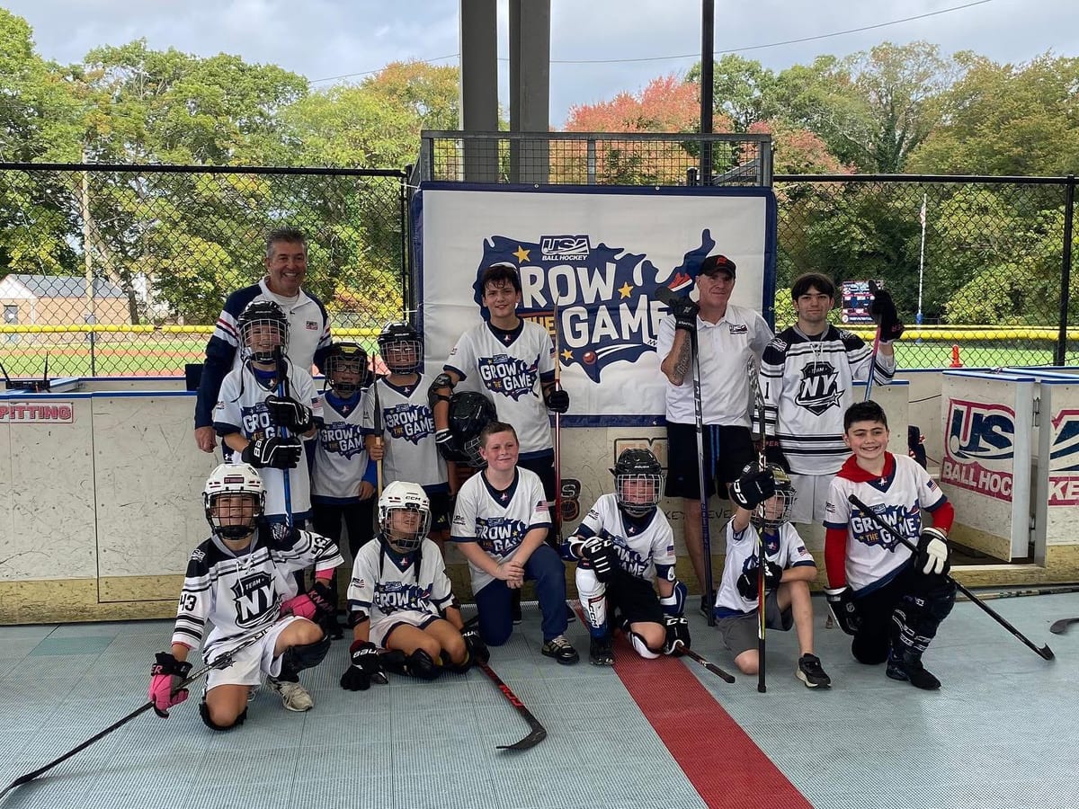 Coach Sal with kids and coaches in front of the USA Ball Hockey Grow the Game backdrop