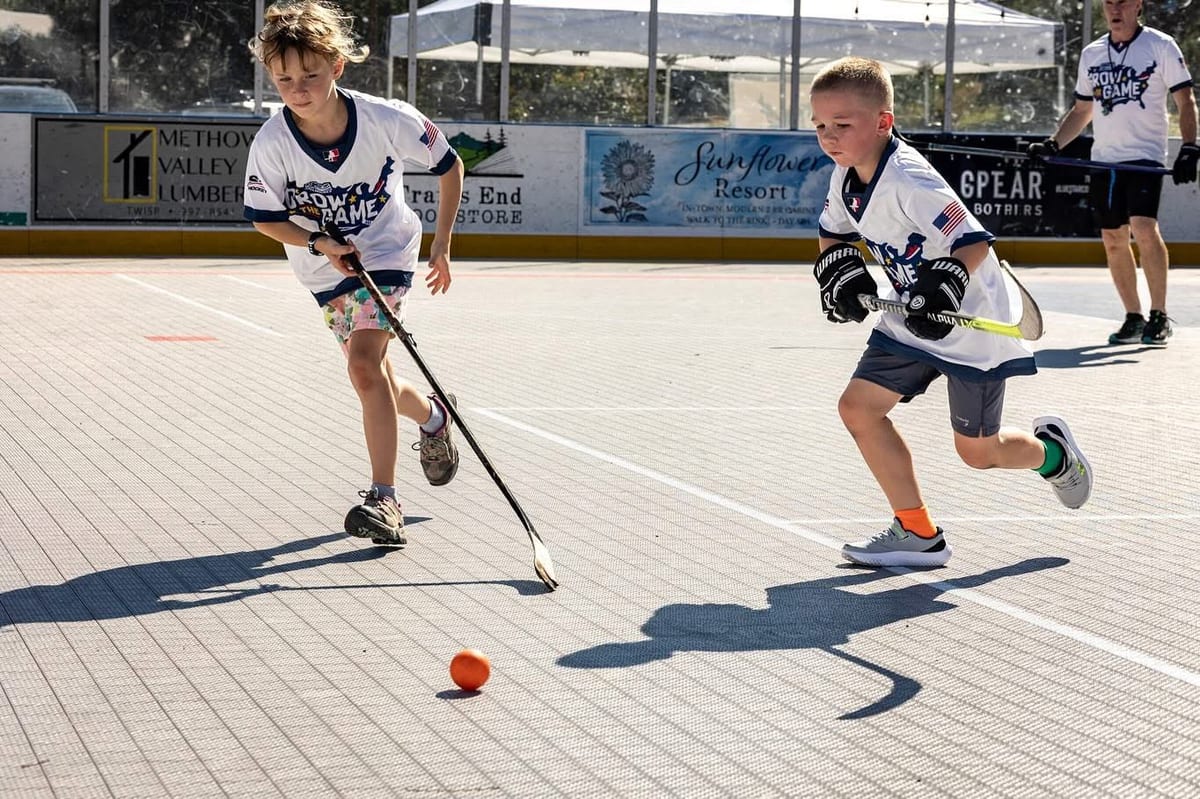 Kids in USA Ball Hockey Grow the Game jerseys chasing the ball on an outdoor rink